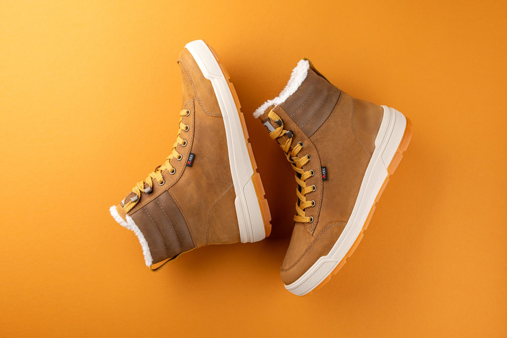 Rieker Herren Stiefelette U0071 in Cognacbraun und warm gefüttert auf gelbem Hintergrund