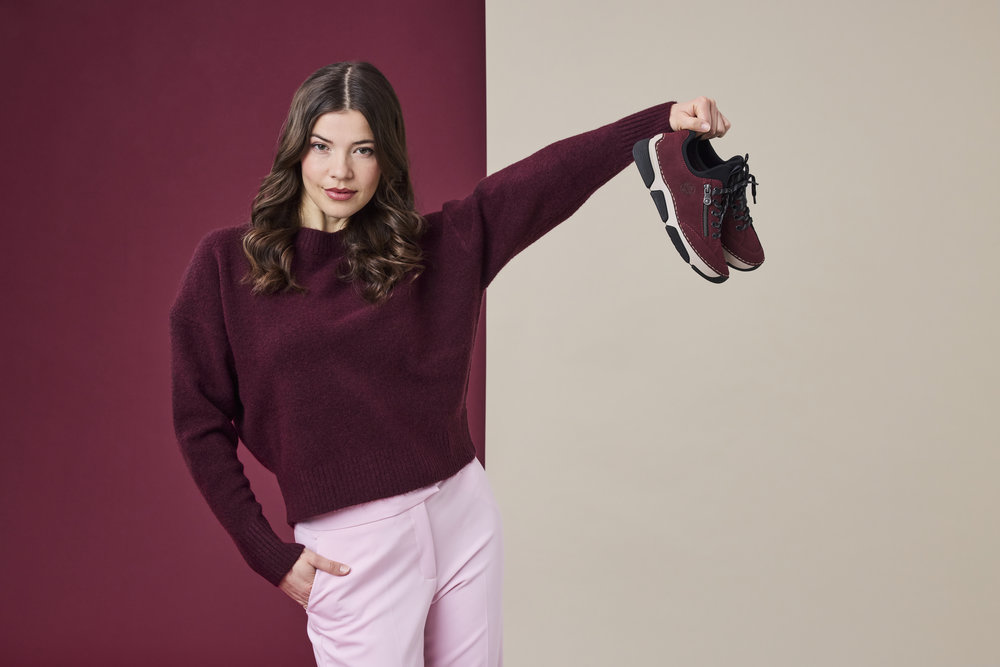 Model hält ein Paar Rieker Sneaker in Rot 45973-36