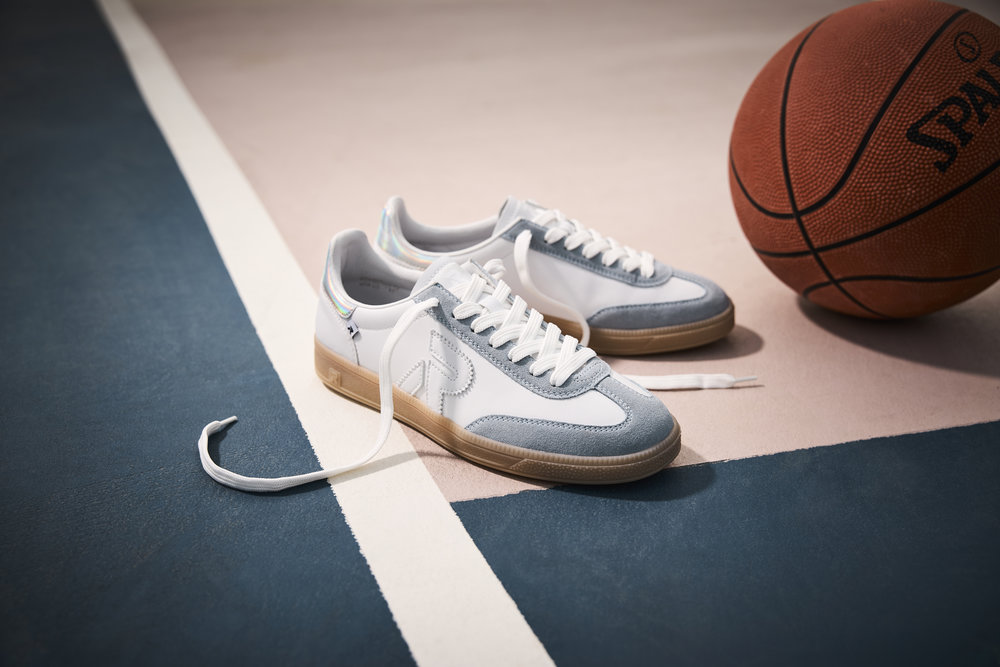 Rieker Damen Retro Sneaker W2200 in Weiß-Blau auf einem Basketballfeld stehend