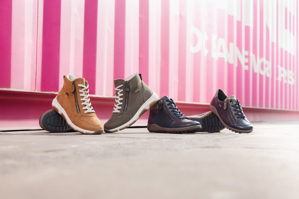 Auswahl an Remonte Damen Winterstiefeletten vor rosa Wand